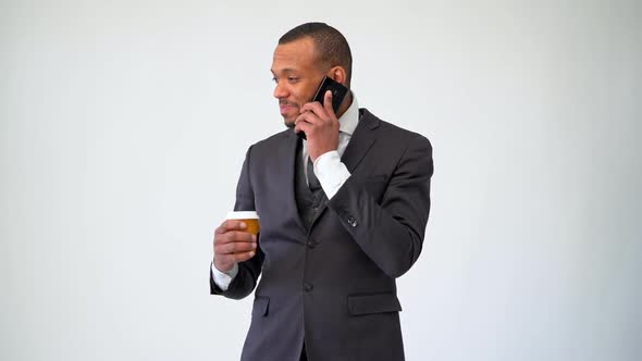 Professional African-american Business Man Holding Cup of Coffee Talking on Mobile Phone