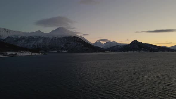 Epic drone view at blue hour of snowy mountain landscape in the Arctic