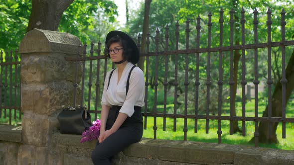 Girl sitting by a fence