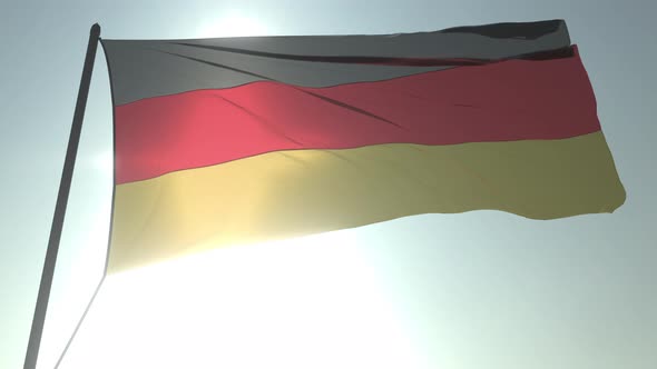 Waving Flag of Germany Against Shining Sun and Sky