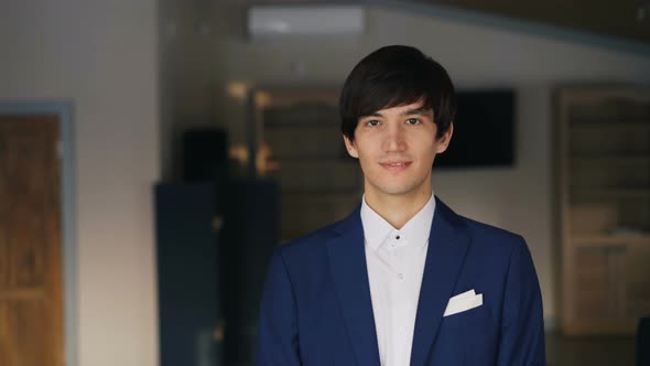 Portrait of Dark-haired Handsome Young Man in Blue Suit and White Shirt