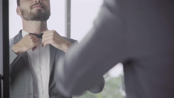 Man in Formal Suit Getting Dressed in Dressing Room for Work or Wedding