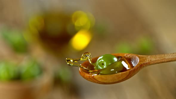 Super Slow Motion Shot of Fresh Olive Splashing Into Olive Oil at 1000 Fps