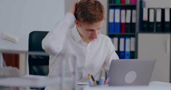 Tensed Businessman Working on Laptop in Office