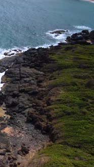 Aerial Vertical Flyover Along Rocks with Waves Crashing the Shore Tilt Up