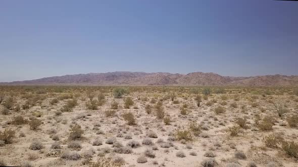 drone flying low over desert landscape