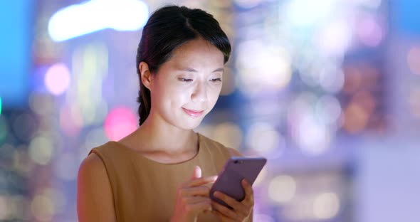 Asian Woman Check on Cellphone in City at Night
