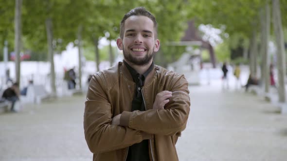 Front View of Smiling Young Man with Crossed Arms