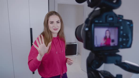 Happy Young Professional Female Blogger Filming Video Blog Using Camera at Home