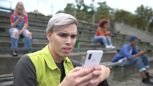 Male Teenager Watching Unpleasant Photo Online, Scrolling Social Network App