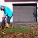 Housekeeper Woman with Leaf Blower Cleaning Path From Colorful Autumn Leaves - VideoHive Item for Sale