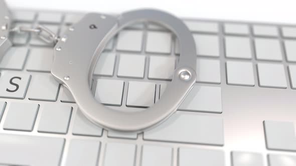 Handcuffs on Keyboard with VIRUS Word on Keys