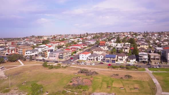 Flying over beach front properties in a countryside with green grass front yard