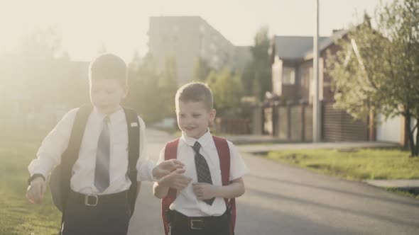 CU, Tracking, Slow Motion: Two Schoolchildren Go Home After School, They Smile, Hug.