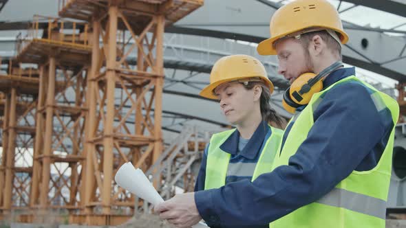 Construction Site Workers Discussing Blueprint