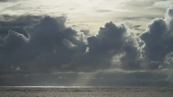 Dramatic clouds above the ocean, beautiful sunlight peaking through the clouds