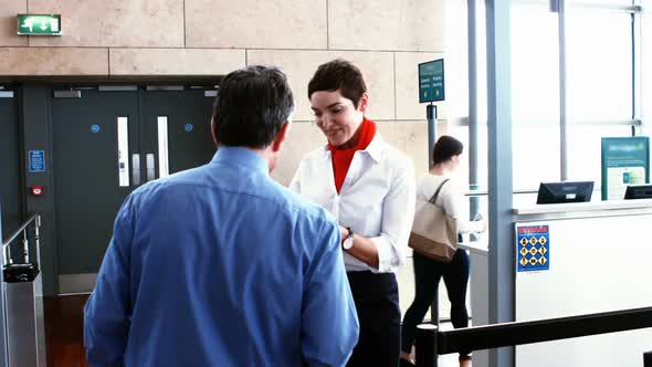 Female airport staff checking passport of commuters