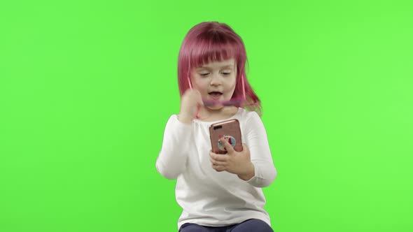 Girl Using Smartphone. Child Emotionally Talking on Mobile Phone, Take Selfie