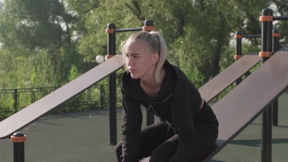 Young Sportswoman Tying Shoelaces On Sports Ground