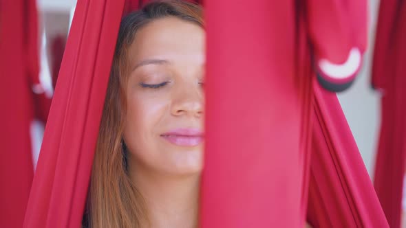 Lady with Perfect Skin Sits in Anti-gravity Yoga Hammock