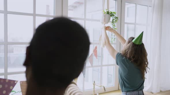 International Couple Hangs Pennant Banners on Flowerpots