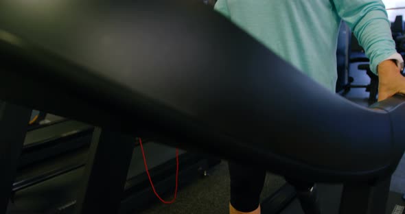 Senior woman using virtual reality headset on treadmill