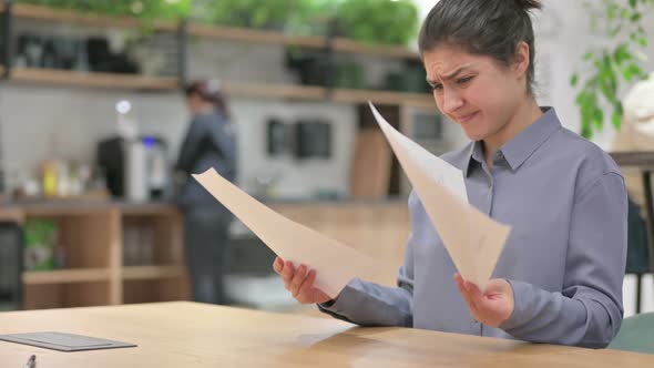 Indian Woman Reacting to Loss While Reading Documents