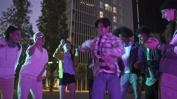 Young Asian Man Dancing with Multiracial Friends at Street Party Having Fun in a Crazy Celebration