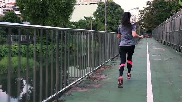 Asian woman running on the street in the city workout lifestyle at sunset.