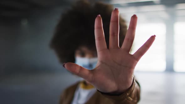 Portrait of african american woman wearing protest face mask in empty parking garage