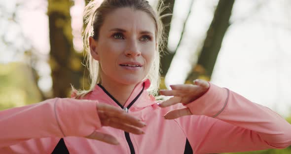 Tilt up view of woman stretching her arms and hands