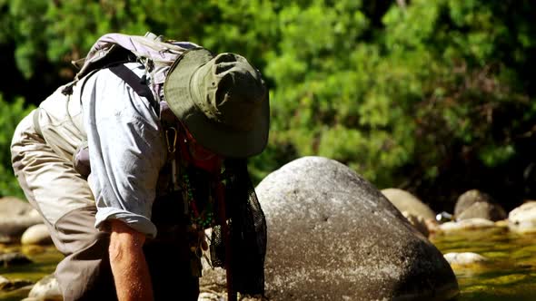 Fly fisherman searching fish in shallow river water