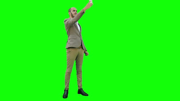 Young Man in Suit Taking Selfies on the Phone on a Green Screen, Chroma Key