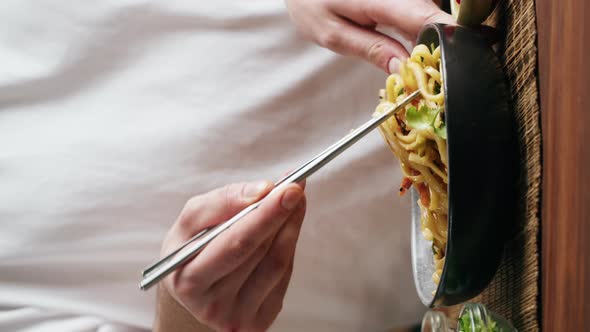 Vertical Video of Chef Cooking Asian Rice Noodles with Fried Meat and Spicy Vegetables in Wok Pan