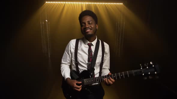 Happy Smiling African American Young Man in Stylish Suit Plays Electric Guitar and Sings a Song