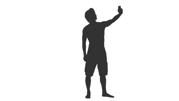 Silhouette of Man Tourist in Shorts Taking Selfie Photo