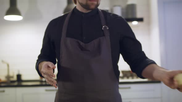 The Chef in an Apron Kneads the Dough