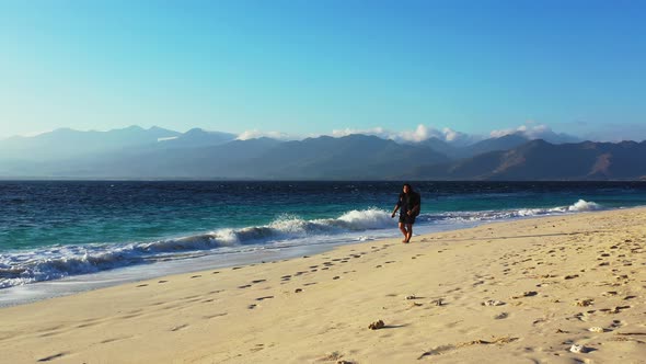 Young happy lady relaxing by the sea on the beach on clean white sand and blue background 4K