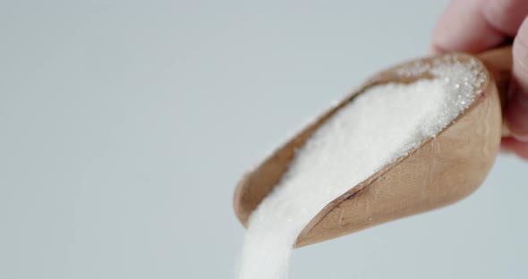 Sugar Is Poured From a Wooden Scoop