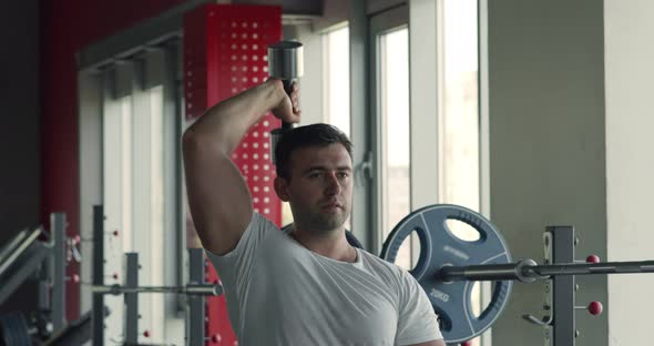 Muscular Man Exercising with Dumbbell at Gym, Practicing Triceps, Biceps Muscles Workout