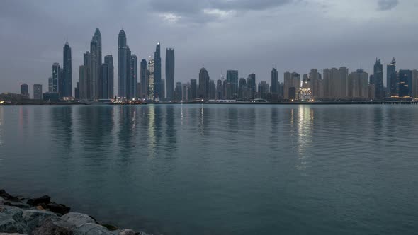 Panorama of Modern Skyscrapers in Dubai City Night to Day Timelapse From the Palm Jumeirah Island