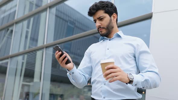 Handsome Man With Phone Drinking Coffee Near Business Office