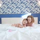 Two Sisters Play Early in the Morning in Bedroom on White King Size Bed - VideoHive Item for Sale