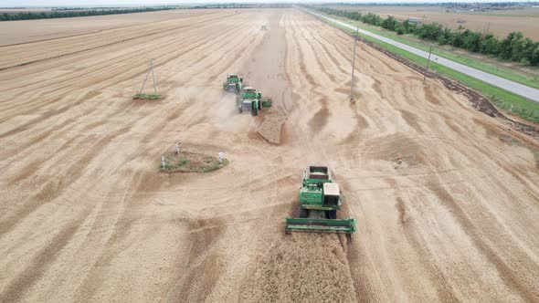 Aerial View of Harvester Machines Working in Wheat Field