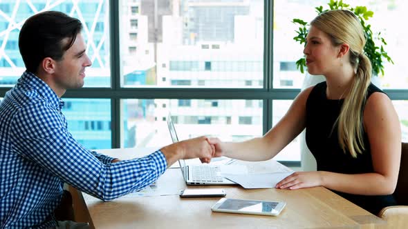 Executives interacting with each other at desk