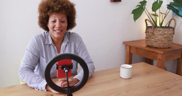 Mature african woman streaming live video with influencer led and smartphone