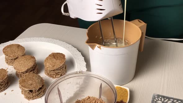 A Woman Adds Condensed Milk To Butter Cream. For A Biscuit Cake With Biscuit Crumbs. Overall Plan.