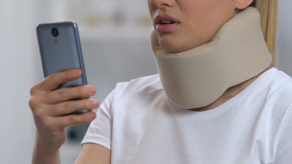 Lady With Smartphone in Foam Cervical Collar Feeling Neck Pain, Rehabilitation