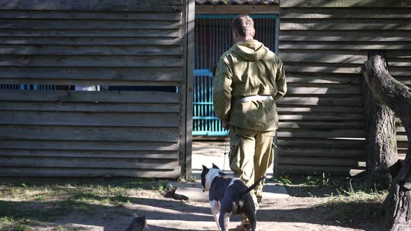 Caucasian Man Holding Dog Collar Walking with American Staffordshire Terrier to Dog Training Center