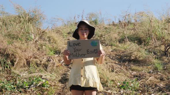 Portrait shot of Asian young female eco acivist standing in tropical forest.